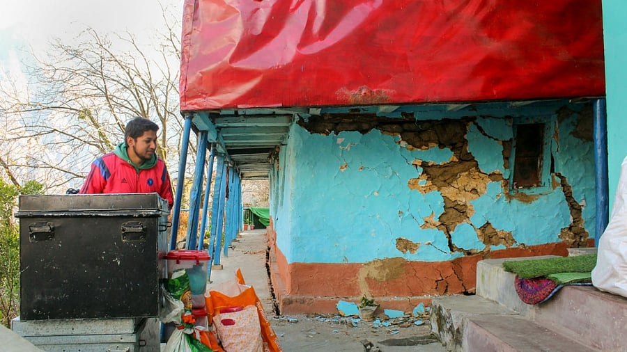 A resident shows cracks that appeared in a house in Joshimath. Credit: PTI Photo