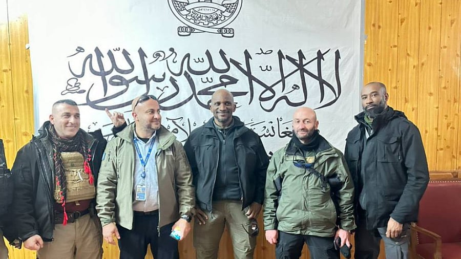 The UN personnel in front of a Taliban flag during a visit to the war-torn country. Credit: Twitter/@alinazary