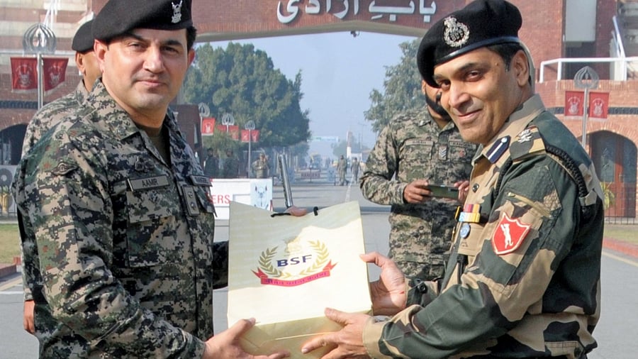 BSF Commandant Jasbir Singh presents sweets to Pakistani Rangers Wing Commander Aamir on the occasion of 74th Republic Day. Credit: IANS Photo