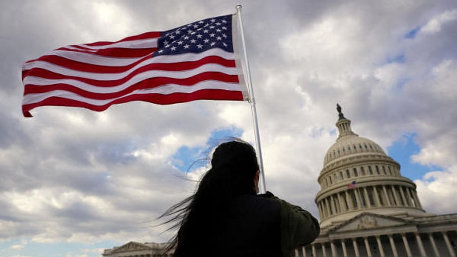 A person holds a flag aloft at the US Capitol, where US President Joe Biden will deliver his the State of the Union Address on February 7. Credit: Reuters Photo
