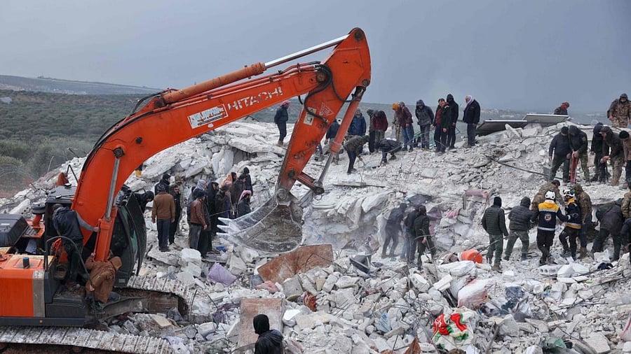 Residents and rescuers search for victims and survivors amidst the rubble of collapsed buildings following an earthquake in the village of Besnaya in Syria's rebel-held northwestern Idlib province on the border with Turkey, on February 6, 2022. Credit: AFP Photo