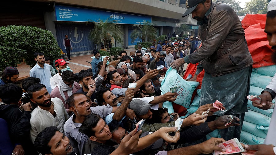Men reach out to buy subsidised flour sacks from a truck in Karachi, Pakistan January 10. Credit: Reuters Photo