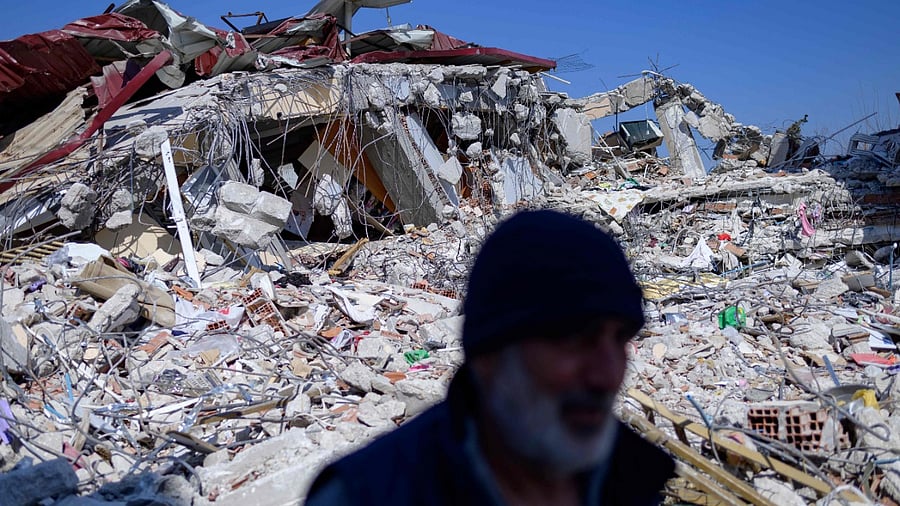 A resident stands in front of his destroyed home in Samandag, south of Hatay on February 16, 2023, ten days after a 7.8-magnitude struck the border region of Turkey and Syria. Credit: AFP Photo
