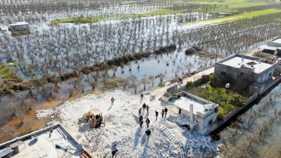 Men work on the rubble of a damaged building at a flooded area in the northwest Syrian town of Al-Tloul, after a dam gave way last week in the aftermath of the deadly earthquake. Reuters Photo