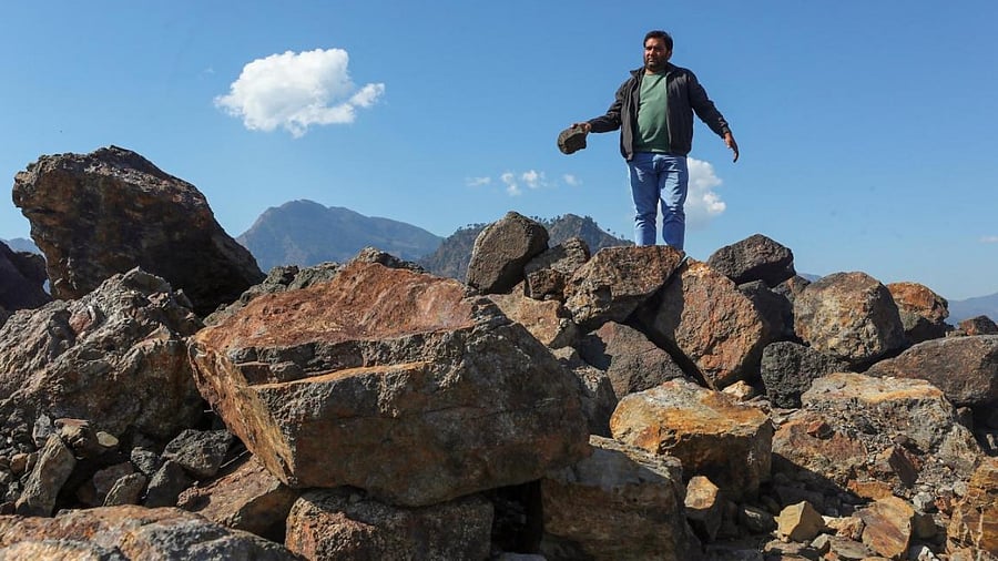 A villager poses with lithium stones in Jammu's Reasi district. Credit: PTI Photo