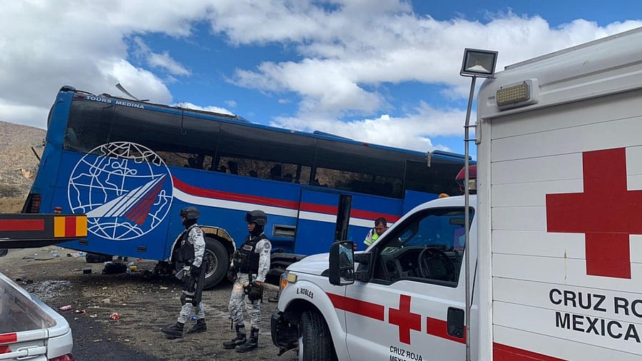 Members of the National Guard stand at the scene of a bus accident which was carrying migrants from Venezuela, Colombia and Central America, in Cuacnopalan, Mexico. Credit: Reuters Photo