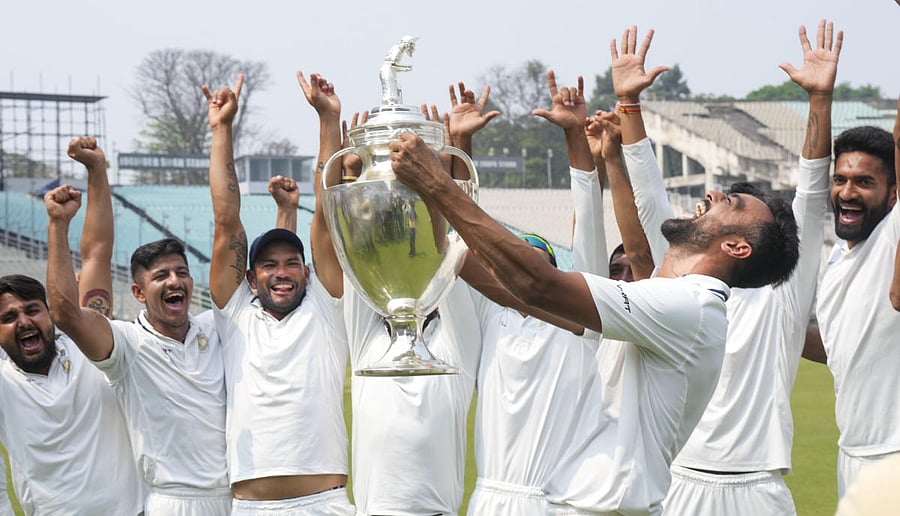 Saurashtra players celebrate with the Ranji Trophy following their nine-wicket win over Bengal. Credit: PTI Photo