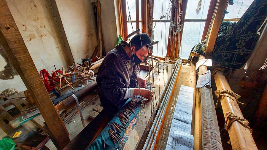 An artisan works on a Kani shawl on a handloom in Srinagar. Credit: PTI Photo