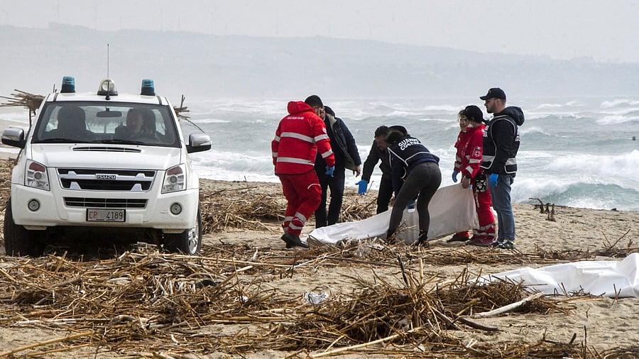 Rescuers recover a body after a suspected migrant boat is wrecked and bodies believed to be of refugees were found in Cutro, the eastern coast of Italy's Calabria region, Italy, February 26, 2023. Credit: Reuters Photo