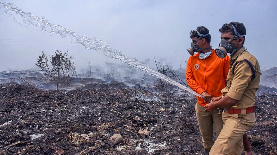 Fire and rescue personnel try to put out the fire which broke out at the Brahmapuram waste treatment plant, in Kochi. Credit: PTI Photo