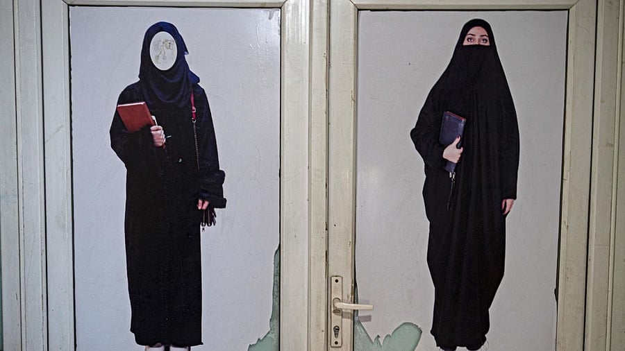A poster pasted on a door ordering women to cover themselves with a Hijab is pictured at a private university after the universities were reopened in Kabul on March 6, 2023. Credit: AFP Photo