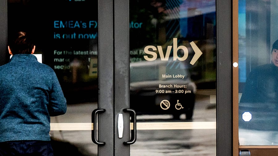 A customer (L) reads a notice about Silicon Valley Bank’s closure at the bank’s headquarters in Santa Clara. Credit: AFP Photo