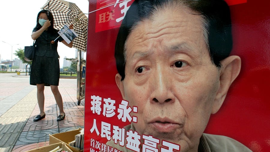 A Chinese woman adjusts her face mask at a newspaper stall featuring a photo of Dr Jiang Yanyong in Beijing. Credit: Reuters Photo