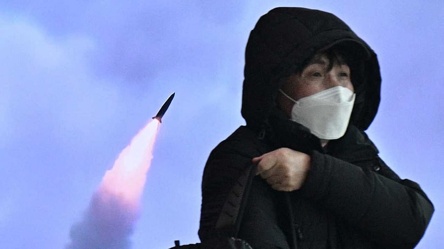 A man walks past a television screen showing a news broadcast with file footage of a North Korean missile test. Credit: AFP Photo