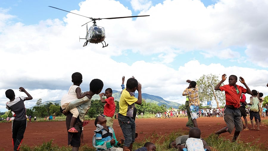 Children in Mulanje looks on as a military helicopter carries doctors and medical supplies to Muloza, on the border with Mozambique, after the tropical Cyclone Freddy cut off supplies, outside Blantyre, Malawi, March 18, 2023. Credit: Reuters Photo