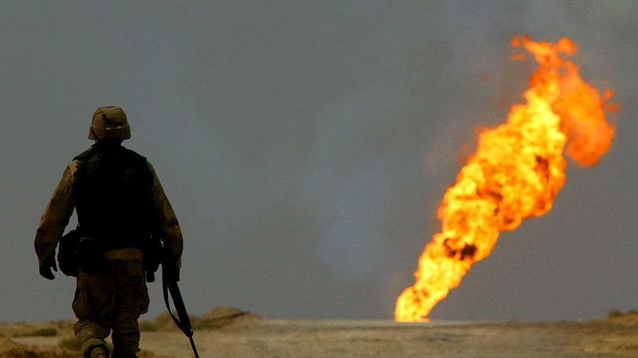 A US Army soldier walks towards a burning oil well in Iraq's vast southern Rumaila oilfields, March 30, 2003. Credit: Reuters Photo