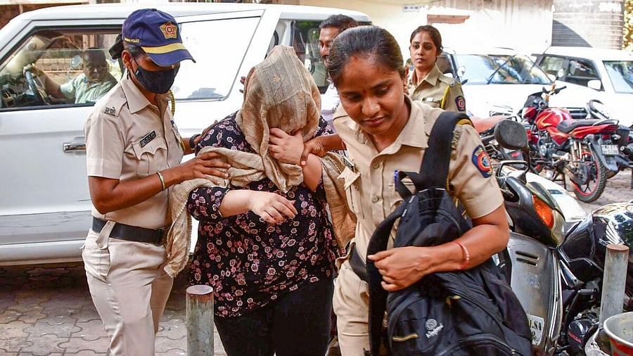 Police personnel take accused designer Anishka Jaisinghani. Credit: PTI Photo