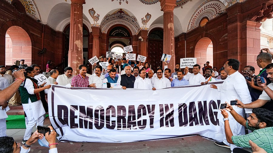 Congress President Mallikarjun Kharge and along with MPs of other like-minded opposition parties holds a 'Democracy in Danger' banner before a protest march towards Rashtrapati Bhawan, at Parliament House complex in New Delhi, Friday, March 24, 2023. Credit: PTI Photo