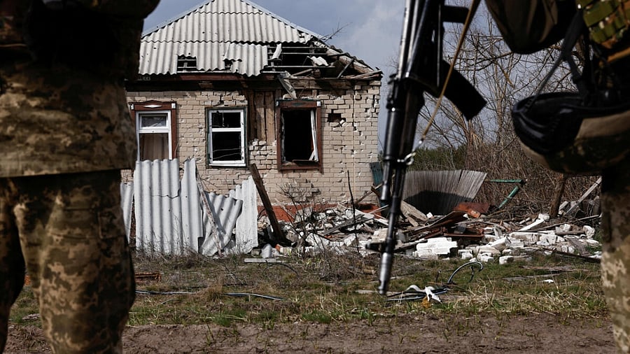 Ukrainian servicemen stand next to a destroyed building near the frontline town of Kreminna, amid Russia's attack on Ukraine, in Luhansk region, Ukraine March 24, 2023. Credit: Reuters Photo