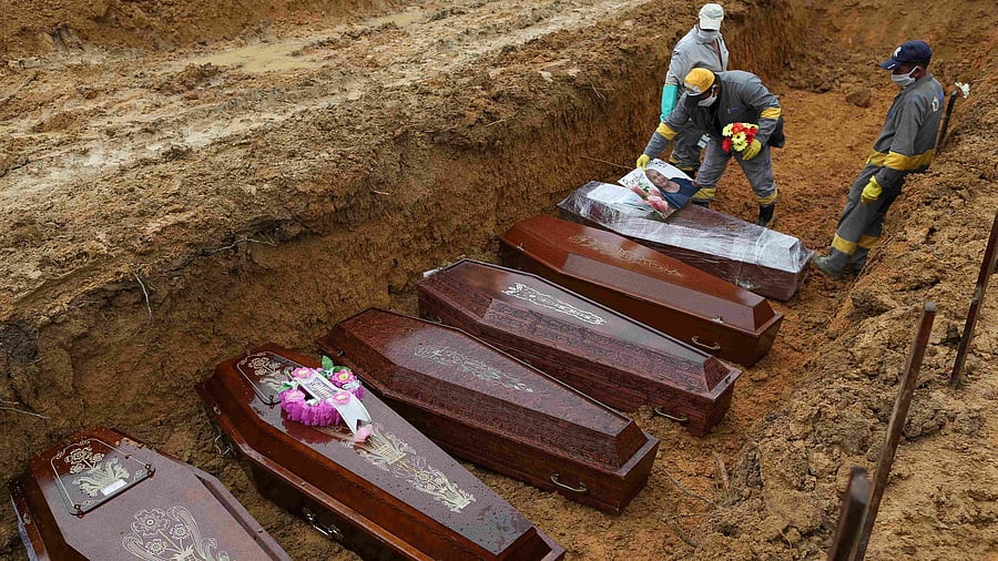 In this file photo taken on May 06, 2020 cemetery workers prepare the coffins to be buried in a mass grave at the Nossa Senhora cemetery in Manaus, Amazon state, Brazil, amid the COVID-19 coronavirus pandemic. - Three years after the first case of Covid-19 was recorded in Brazil -the world's second-most stricken by the pandemic- the country reached 700,000 deaths caused by this virus the Health Ministry said, on March 28, 2023. Credit: AFP Photo