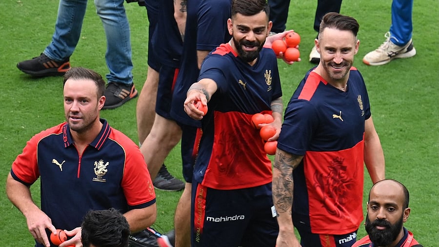 Bengaluru (RCB) cricketers Faf du Plessis, Virat Kohli and former team mate AB de Villiers (L) take part in RCB Unbox, a promotional event held at the M Chinnaswamy Stadium prior to the start of the annual Indian Premier League (IPL) cricket tournament, in Bengaluru on March 26, 2023. Credit: AFP Photo
