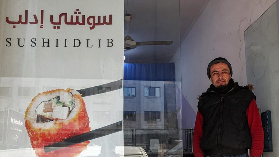 Islam Shakhbanov stands at the entrance of his sushi restaurant in Syria's rebel-held northwestern city of Idlib. Credit: AFP Photo