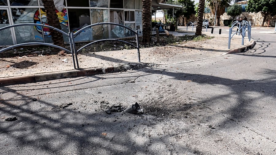 The remains of a rocket is seen stuck in the ground outside a damaged building of a bank, following incoming rockets from Lebanon to Israel in Shlomi, northern Israel April 6, 2023. Credit: Reuters Photo