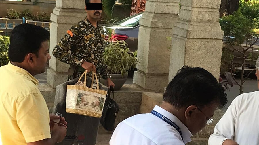A marshal carries bags belonging to a BBMP officer. This image is from the BBMP head office in Hudson Circle. Credit: DH Photo/Naveen Menezes