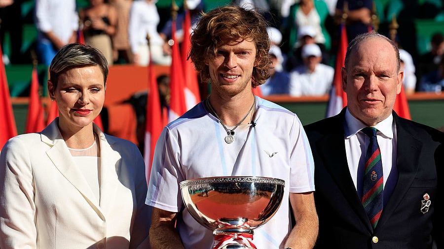 Russia's Andrey Rublev celebrates with his trophy next to Prince Albert II of Monaco (R) and Princess Charlene of Monaco (L) after winning the final Monte-Carlo ATP Masters Series tournament tennis match against Denmark's Holger Rune in Monte Carlo on April 16, 2023. Credit: AFP Photo