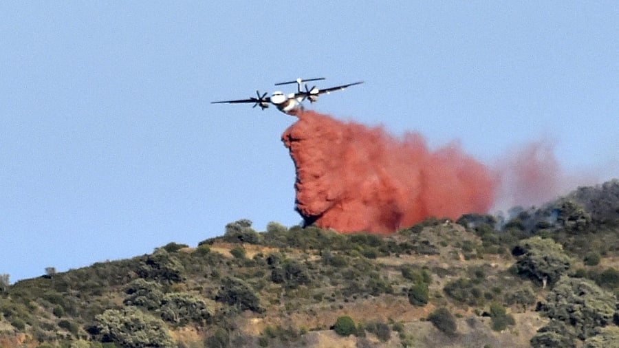 A plane drops fire retardant over a forest fire on a hill near the village of Banyuls-sur-Mer, southwestern France on April 16, 2023. Credit: AFP Photo