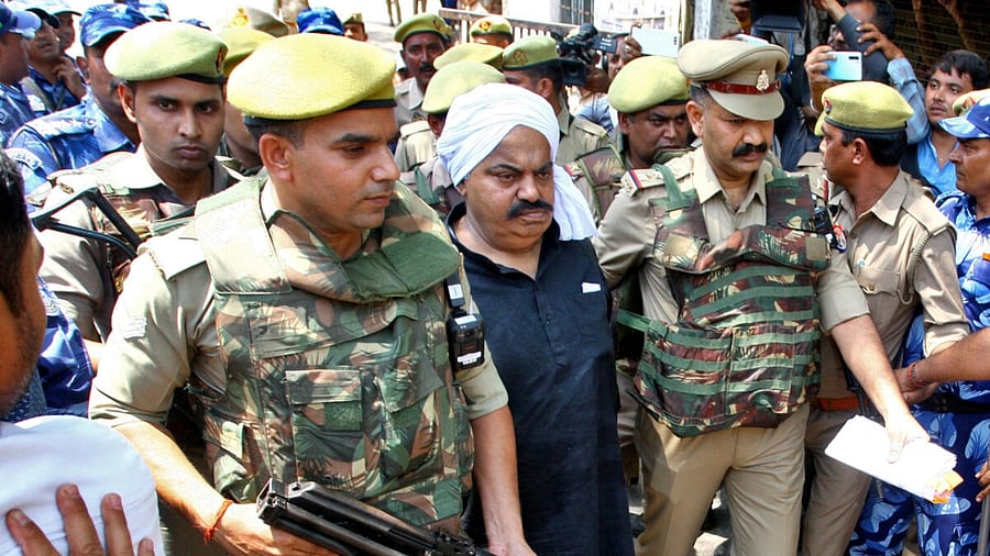 Police officers escort Atiq Ahmed outside a court in Prayagraj. Credit: Reuters Photo