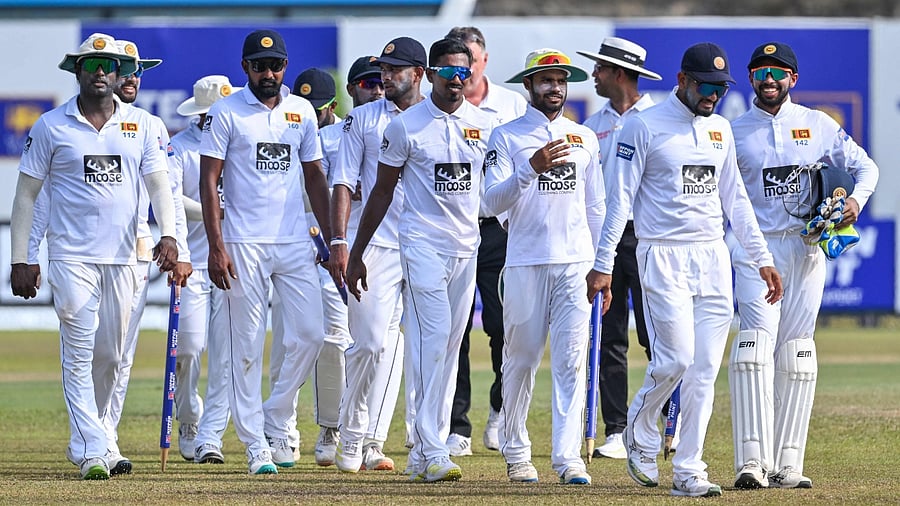 Sri Lanka's captain Dimuth Karunaratne with teammates walk back to the pavilion after Sri Lanka won by an innings and 280 runs during the third day of the first cricket Test match. Credit: AFP Photo