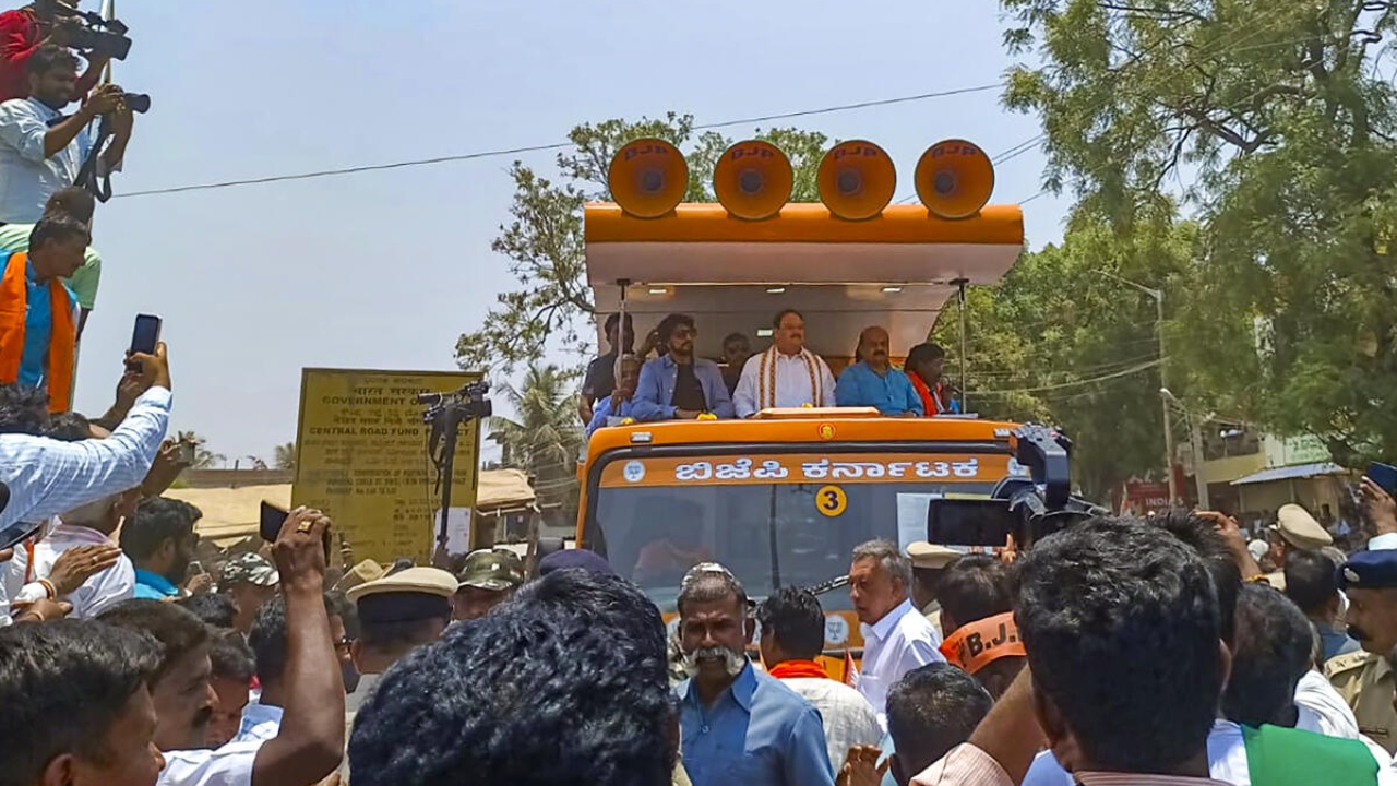 BJP National President JP Nadda with Karnataka CM Basavaraj Bommai and Kannada actor Kiccha Sudeep during a roadshow in support of Bommai ahead of Karnataka Assembly elections, in Haveri district, Wednesday, April 19, 2023. Credit: PTI Photo