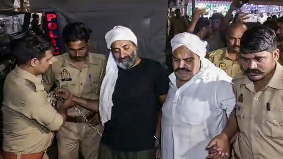 Gangster-turned-politician Atiq Ahmed and his brother Ashraf Ahmed being escorted to a hospital by police for a medical checkup in Prayagraj, Saturday, seconds before they were shot dead by assailants posing as media persons. Credit: PTI Photo
