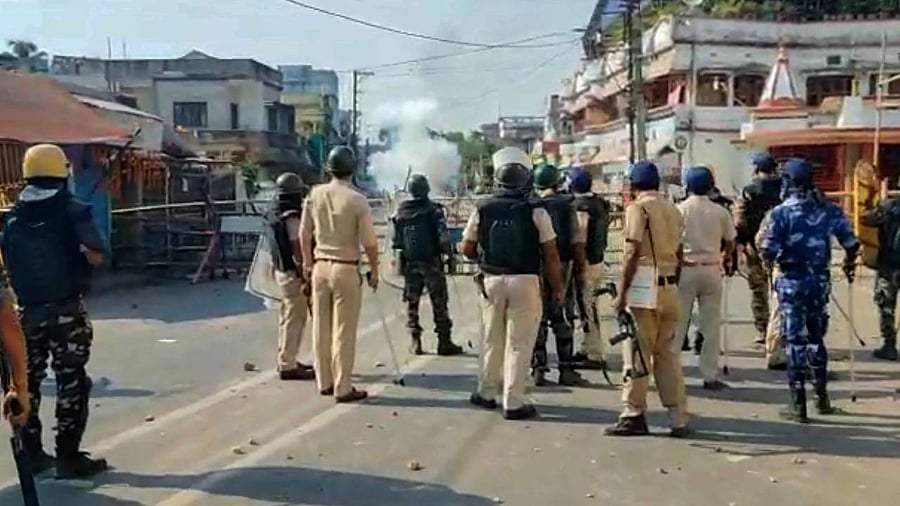 Security personnel stand guard after a group of protesters allegedly set Kaliaganj Police Station on fire during a protest against the death of a minor girl. Credit: PTI Photo