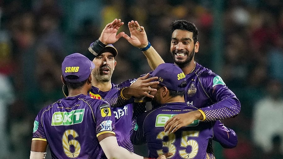 Kolkata Knight Riders bowler Varun Chakaravarthy celebrates with teammates after taking the wicket of Royal Challengers Bangalore batter Dinesh Karthik during the IPL 2023 cricket match between Royal Challengers Bangalore and Kolkata Knight Riders at M Chinnaswamy Stadium in Bengaluru. Credit: PTI Photo