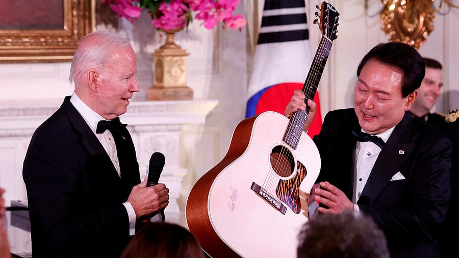 Joe Biden presents a guitar signed by artist Don McLean to South Korea's President Yoon Suk Yeol. Credit: Reuters Photo