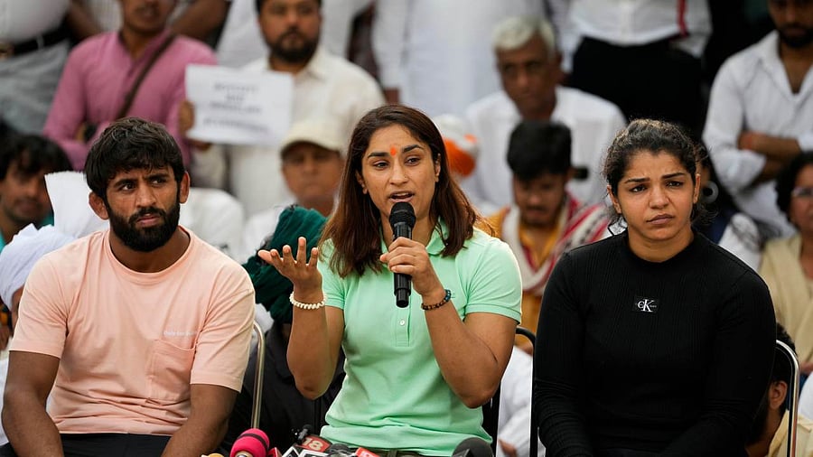 Wrestlers Bajrang Punia, Vinesh Phogat and Sakshi Malik address a press conference during their ongoing protest at Jantar Mantar. Credit: PTI Photo
