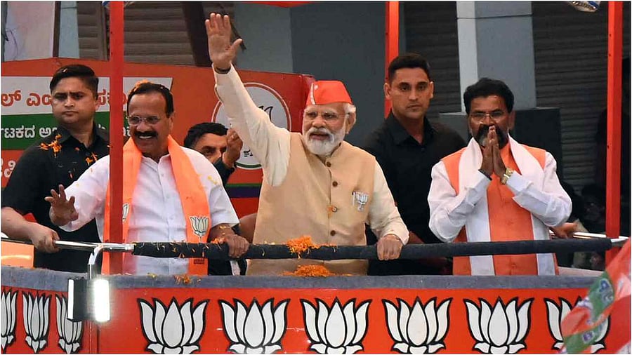 Prime Minister Narendra Modi waves at crowd during a roadshow in support of BJP candidates for upcoming Assembly polls, in Bengaluru, Saturday, April 29, 2023. Credit: DH Photo