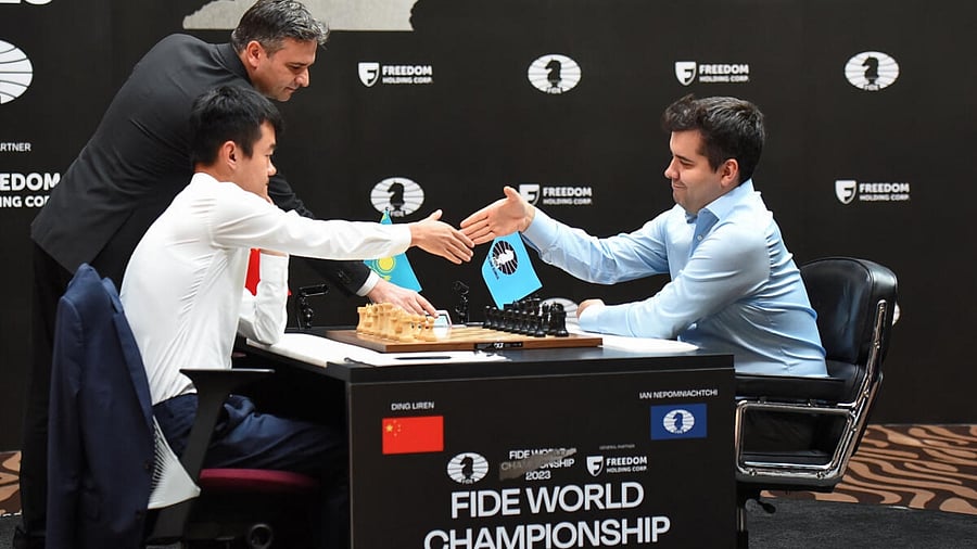 FIDE World Championship Match 2023 - Game 14 - Astana, Kazakhstan - April 29, 2023. Ding Liren of China shakes hands with Ian Nepomniachtchi of International Chess Federation. Credit: Reuters Photo
