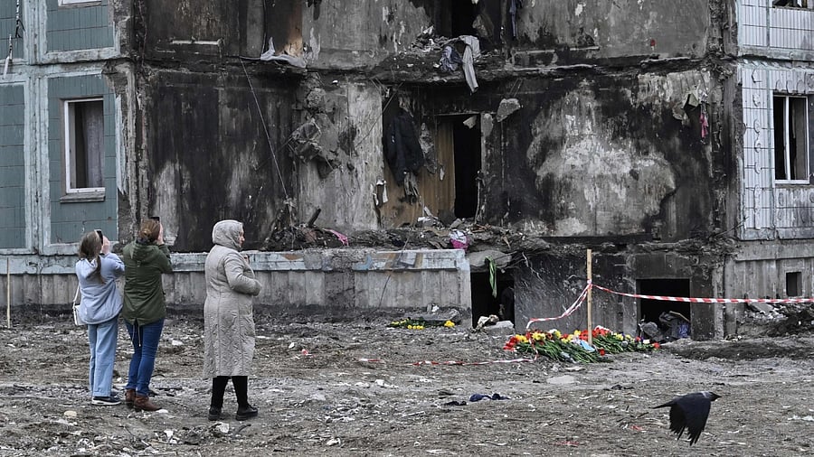 People pay their respects in front of a damaged multistory residential building, where a Russian strike killed 23 people, in Uman, Cherkasy region, on April 30, 2023. Credit: AFP Photo