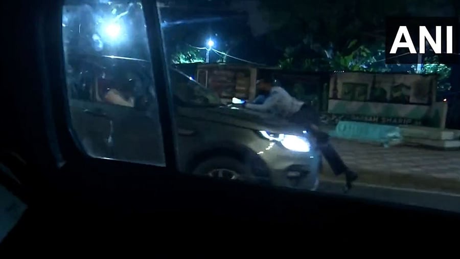 Screengrab from a video showing the man being dragged on the bonnet of the SUV. Credit: Twitter/@ANI