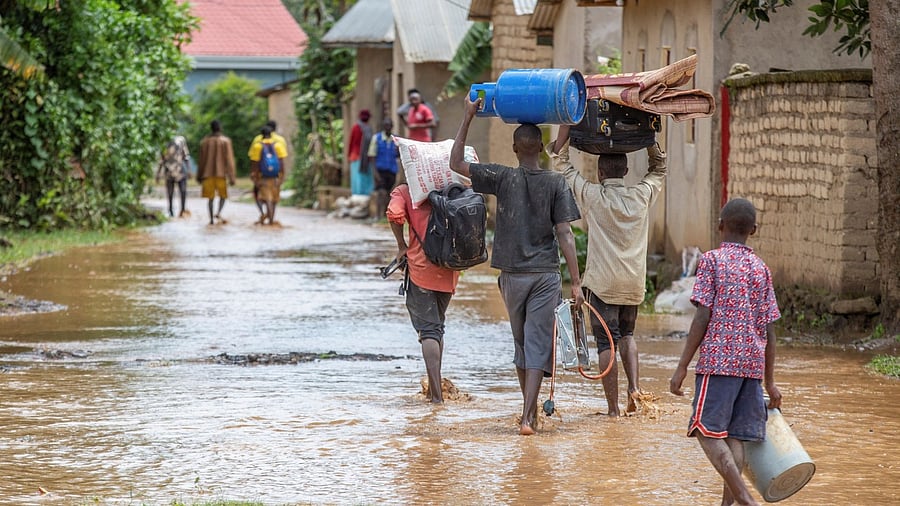 Residents wade through water after their homes were swamped following rains that triggered flooding and landslides in Rubavu district, Western province, Rwanda. Credit: Reuters Photo