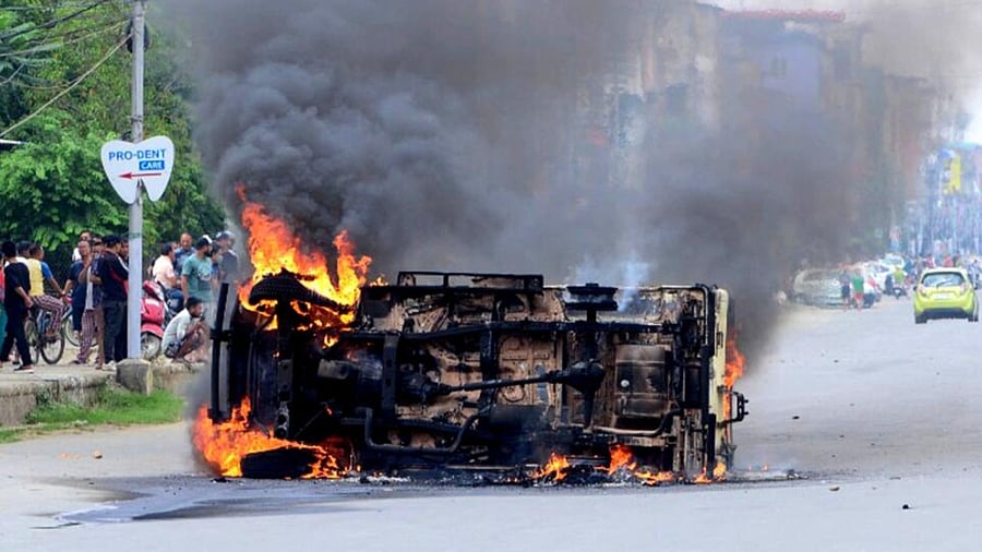 In this picture taken on May 4, 2023, smoke billows from a vehicle allegedly burned by the Meitei community tribals protesting to demand inclusion under the Scheduled Tribe category, in Imphal. Credit: AFP Photo