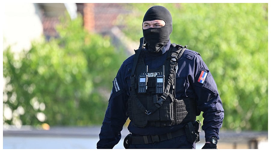 A masked policeman secures an area in the village of Dubona near the town of Mladenovac, about 60 kilometres (37 miles) south of Serbia's capital Belgrade, on May 5, 2023. Credit: AFP Photo