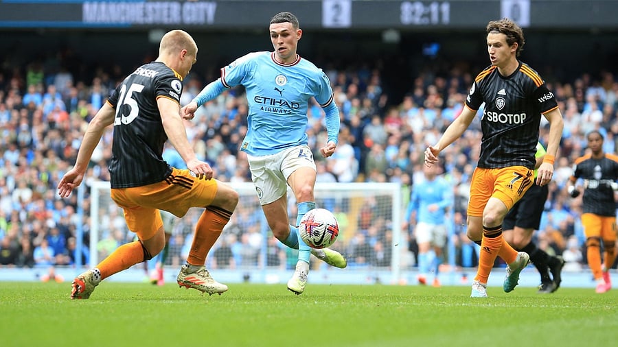 Manchester City's English midfielder Phil Foden (C) fights for the ball with Leeds United's Danish defender Rasmus Kristensen (L) during the English Premier League football match between Manchester City and Leeds United at the Etihad Stadium in Manchester. Credit: AFP Photo