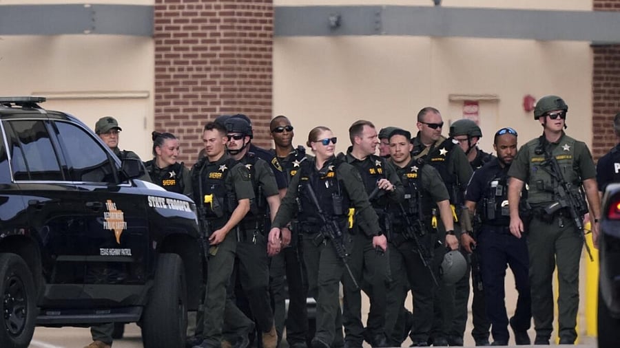 Law enforcement officers walk at a shopping center after the shooting. Credit: AFP Photo