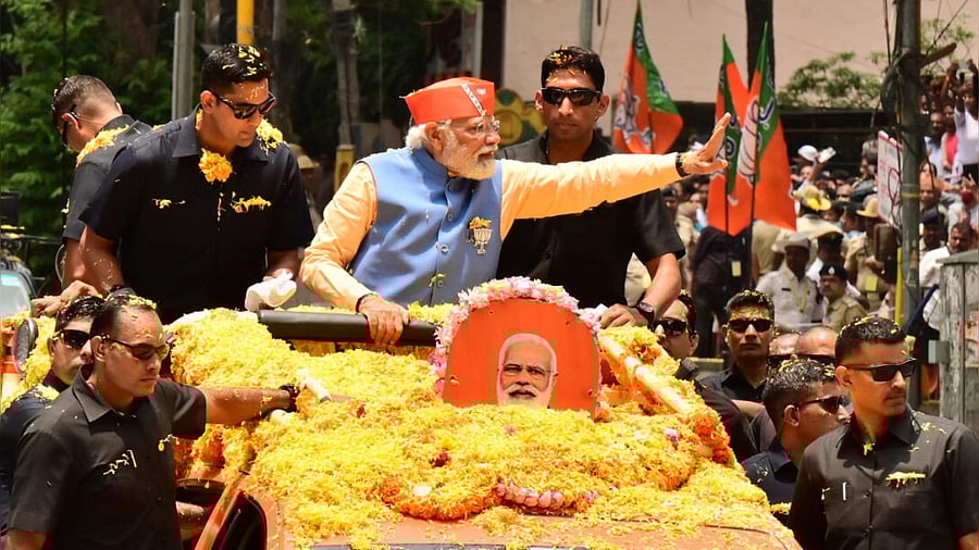Prime Minister Narendra Modi waves at people during the roadshow at JP Nagar, Bengaluru on Saturday, ahead of Karnataka assembly elections on Saturday. DH PHOTO/PUSHKAR V