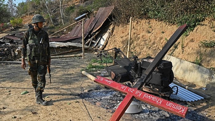 An Indian army soldier inspects the debris of a ransacked church that was set on fire by a mob in the ethnic violence hit area of Senapati district in Manipur on May 8, 2023. Credit: AFP Photo