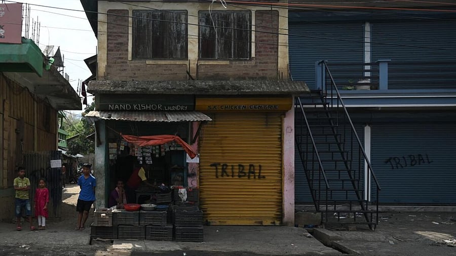 Local residents stand next to shops in Churachandpur as violence hit the northeastern Indian state of Manipur on May 9, 2023. Credit: AFP Photo